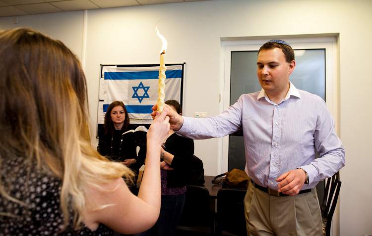 Der junge Rabbi der Reformgemeinde entzündet die geflochtene Kerze für die Hawdala-Zeremonie. (Marta Kusmierz, n-ost)
