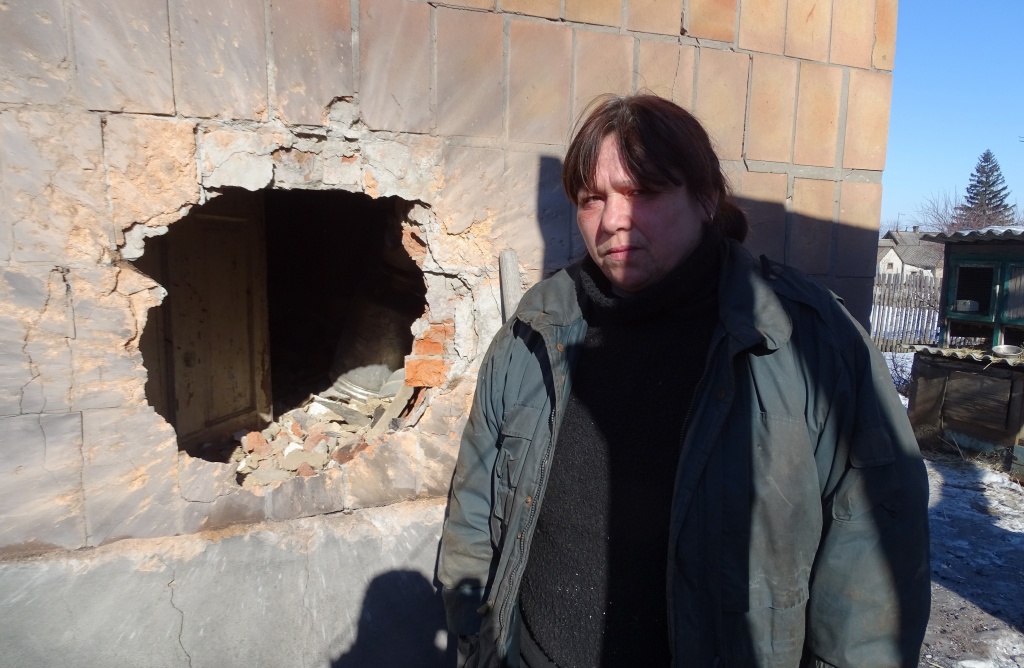 Der Krieg hinterlässt Wunden: Viktoria Petrowna vor dem Einschussloch in ihrem Haus im &quot;alten Awdijiwka&quot;. Foto: Simone Brunner, n-ost