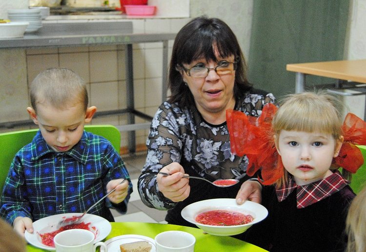 Die dreijährige Wika ist mit ihrer Zwillingsschwester seit ein paar Wochen im Heim. Davor war sie in der Strafkolonie mit ihrer Mutter untergebracht. Essen kann Wika nicht allein, Erzieherin Jelena Kolesnikowa füttert sie mit Borschtsch. / Inna Hartwich, n-ost