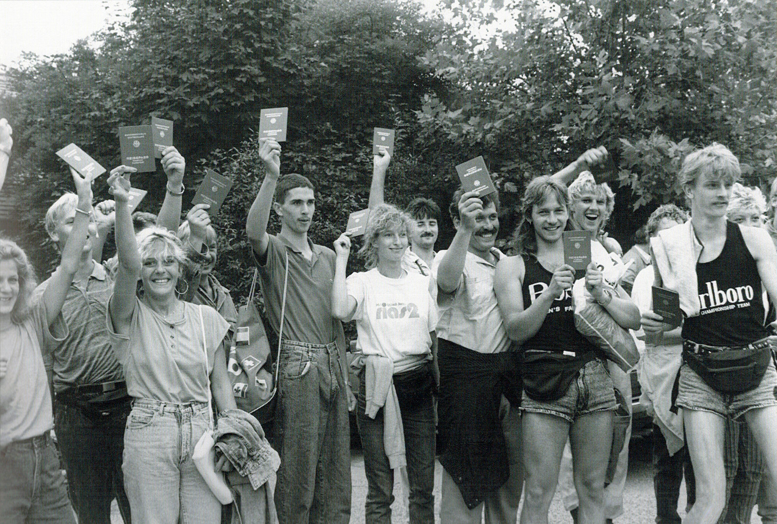 Hunderte von DDR-Bürgern überquerten während des Paneuropäischen Picknicks am 19. August 1989 ungehindert die Grenze von Ungarn nach Österreich. Eine Gruppe dieser Flüchtlinge posiert hier glücklich mit ihren neuen westdeutschen Reisepässen / Foto via http://bit.ly/UF1Rfq auf Wikipedia (CC BY-SA 3.0)