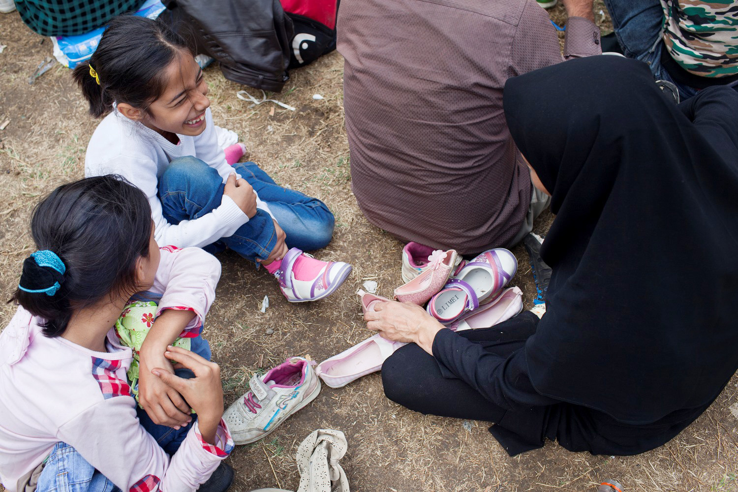 Freude über neue Schuhe: Viele Belgrader helfen den Flüchtlingen, die am Bahnhof Zwischenstopp machen. Hier einer Familie aus Afganistan. / Foto: Marko Risovic, Kamerades, n-ost