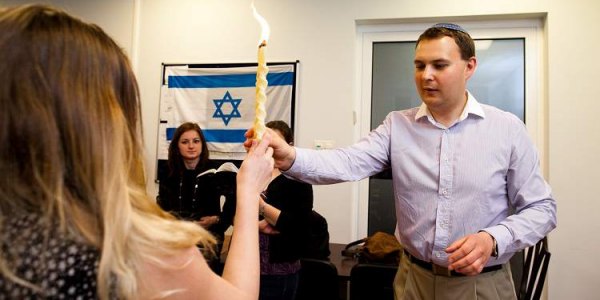 Der junge Rabbi der Reformgemeinde entzündet die geflochtene Kerze für die Hawdala-Zeremonie. (Marta Kusmierz, n-ost)