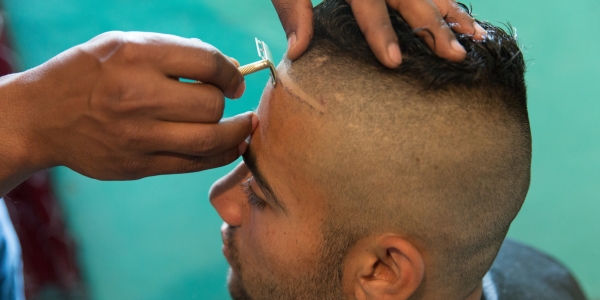 Bente lässt sich von seinem Freund Dragos, dem ersten Friseur des südrumänischen Dorfes Ocolna, einen extravaganten Haarschnitt verpassen. / Foto: George Popescu, n-ost