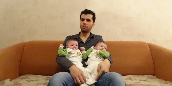 Shaadi mit seinen Zwillingen in der Moskauer Wohnung. Die beiden Mädchen sind zwar in Russland geboren, haben aber keine offiziellen Papiere. / Foto: Simone Brunner, n-ost