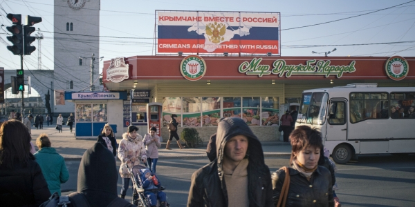 „Die Bewohner der Krim, zusammen mit Russland“, steht auf dem Plakat am Bahnhof in Simferopol. Am 16. März jährt sich das Referendum auf der Halbinsel zum ersten Mal. / Foto: Ramin Mazur, n-ost